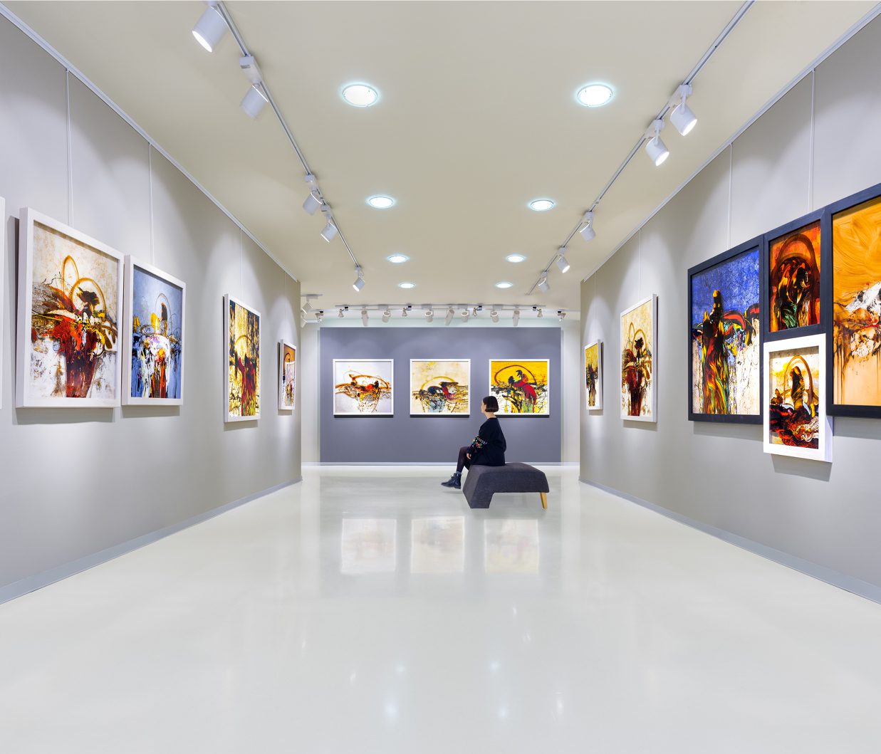 Person sitting in art gallery exhibition room.