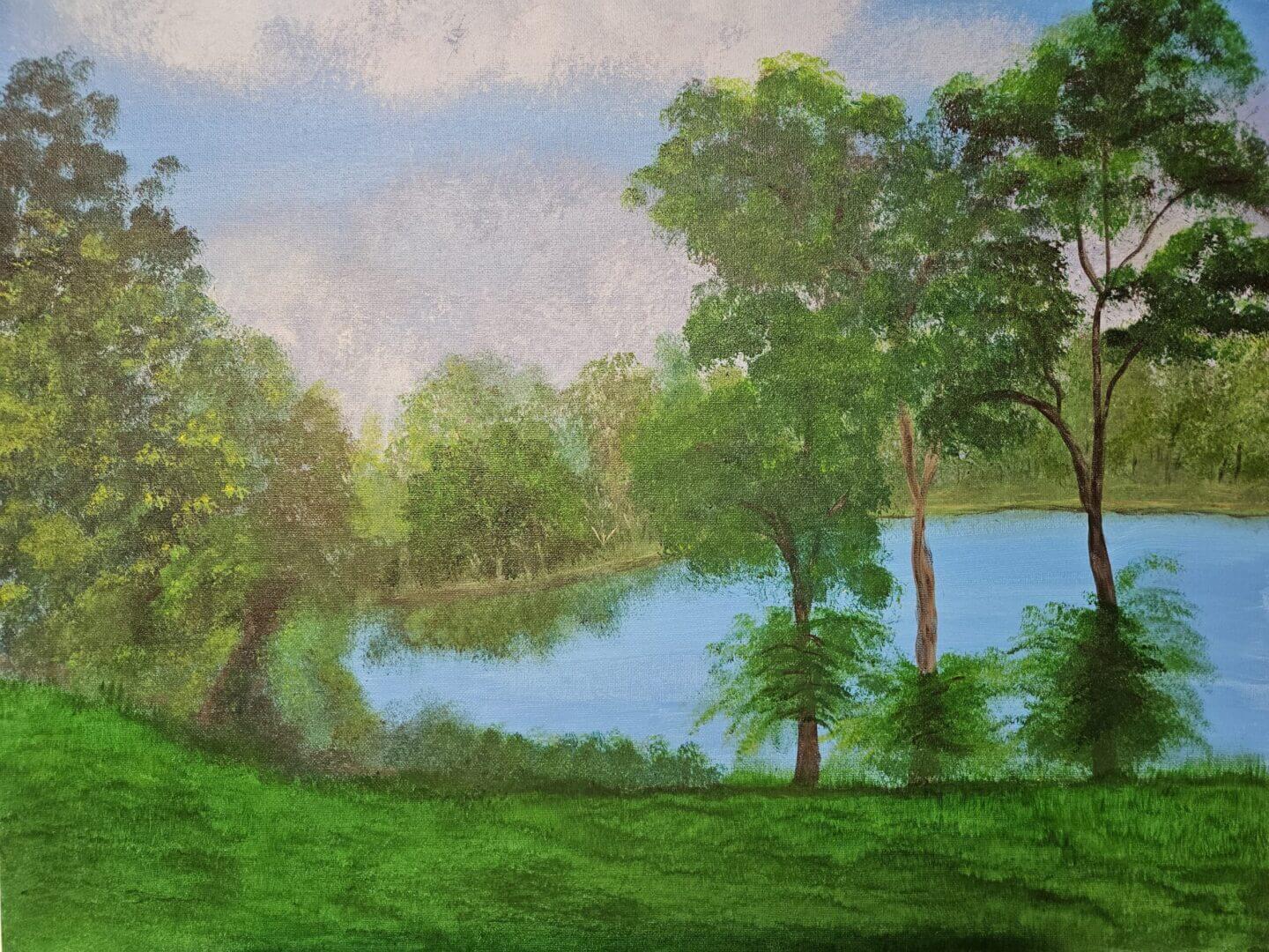 A peaceful lakeside scene with lush green trees and grass under a soft blue sky.